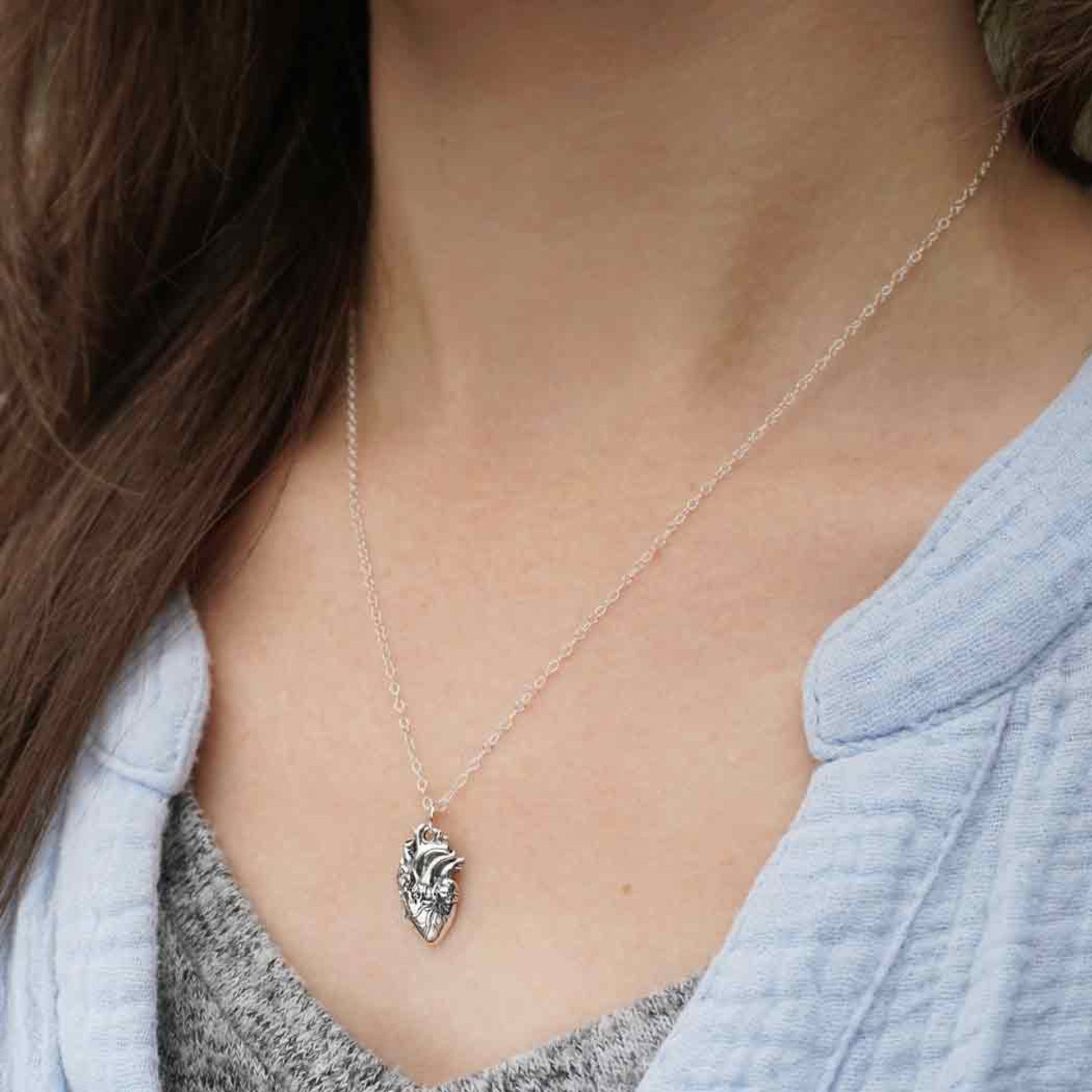 Sterling silver anatomical heart necklace, edgy and romantic charm design.