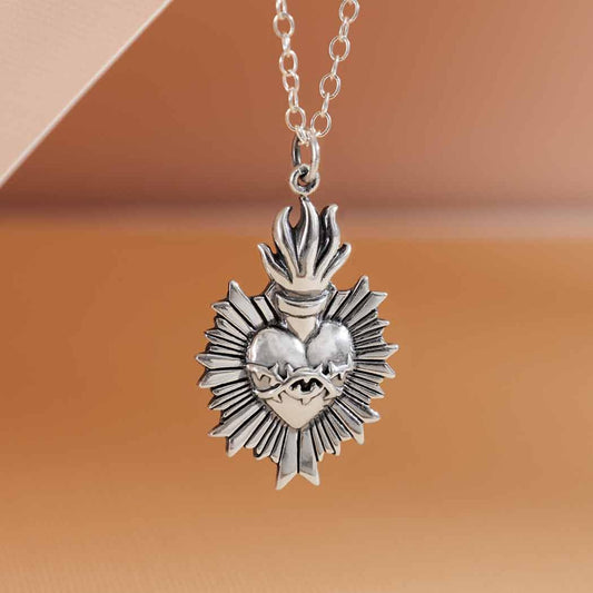 Sterling silver flaming sacred heart necklace, thorn details, radiant design.