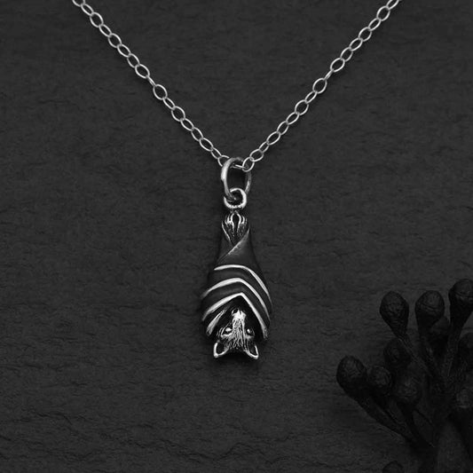 Sterling silver hanging bat necklace with wings wrapped, gothic charm.